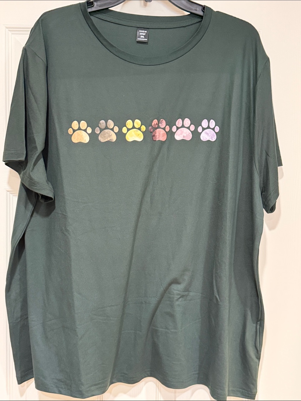 Green top with multicolored paw prints